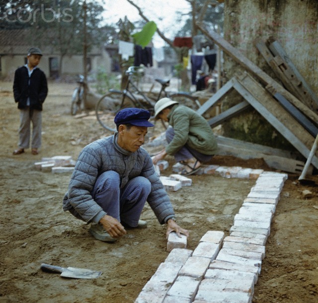 Tháng 3/1973. Những người đàn ông đang xây lại căn nhà trên phố Khâm Thiên, Hà Nội. Ảnh. © Werner Schulze-dpa-Corbis.